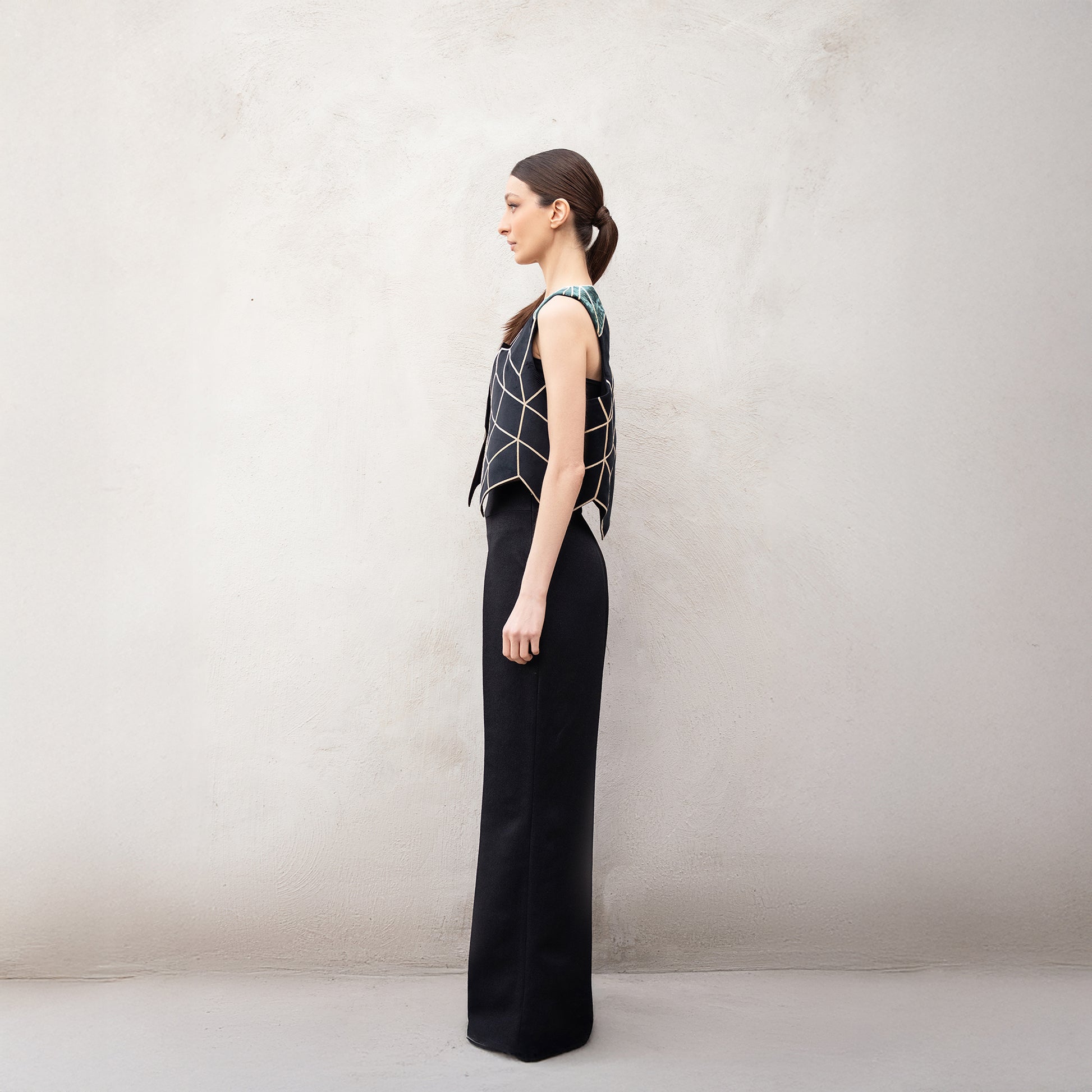 Side profile of the Panther Facad vest, showing the structured silhouette, golden angular design, and green velvet shoulders.