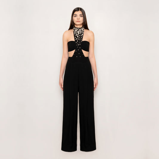 Front view of the Crystal Jumpsuit by Tehran, featuring a chic halterneck design with a tasteful side slit. The ruched detailing and high-waisted silhouette create an elegant and flattering look in black.